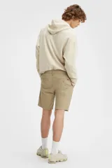 Bermuda color beige de corte chino, con tiro medio y calce recto.