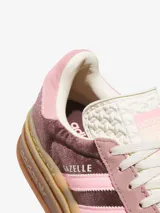Zapatillas Adidas Gazelle Bold con plataforma, capellada de terciopelo color marrón y rosa, con las tres tiras laterales en rosa claro y suela de goma color caramelo.