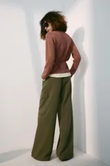 Chaqueta de punto color marrón con detalles en tono marfil en el escote en V, los puños y el ruedo. Cuenta con manga larga, cierre frontal con botones y un cinturón fino ajustable del mismo tejido.