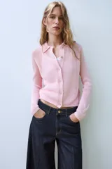 Chaqueta de punto color rosado con cuello polo, manga larga y cierre frontal con botones.