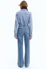 Pantalón de jean celeste de tiro alto, corte ancho y recto, con cinco bolsillos y cierre con botón.