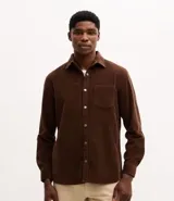 Camisa de hombre confeccionada en tejido de pana (cotelé) de algodón, con cuello solapa, cierre frontal abotonado, mangas largas con puños y un bolsillo aplicado en el pecho.