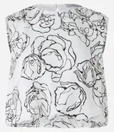 Blusa corta sin mangas confeccionada en crepé con cuello redondo y cierre por gota en la parte posterior. Presenta un estampado floral en blanco y negro.