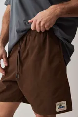 Short de gabardina color beige con calce relajado, cintura elástica con cordón ajustable y largo a mitad de muslo.
