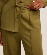 Pantalón recto de tiro alto color azul marino, confeccionado en piqué, con cintura elástica, cordón ajustable y costura central en la parte delantera.