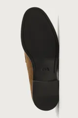 Mocasín casual fabricado en piel con acabado de serraje, con detalle de bordón y antifaz en el empeine, horma redonda y suela a contraste.