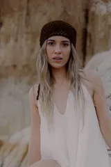 Bandana tejida a crochet con diseño triangular y terminaciones en cordones para anudar. Es un accesorio versátil que puede utilizarse como cinturón o como pañuelo para la cabeza.