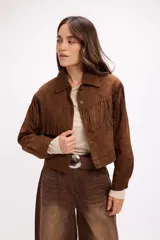 Chaqueta de efecto gamuza en color marrón, con diseño de inspiración western que presenta flecos en la parte frontal y en la espalda. Cuenta con cuello clásico, cierre frontal con botones metálicos a presión y mangas largas.