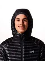 Campera puffer ultraligera Mountain Hardwear, modelo Ghost Whisperer, color negro. Confeccionada en tejido ripstop reciclado con aislamiento de plumón de 800 hilos. Cuenta con capucha, cierre frontal completo, dos bolsillos laterales con cremallera y diseño altamente compactable.