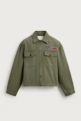 Cazadora cropped de algodón color verde militar, con cuello solapa, cierre frontal de cremallera y bolsillos frontales con solapa. Incluye parches bordados decorativos en el pecho y efecto lavado.