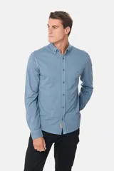 Camisa de manga larga color verde oscuro, con cuello abotonado y logo bordado en el pecho.