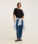 Blusa básica lisa de algodón color negro, con cuello redondo y mangas cortas, de corte clásico y versátil.