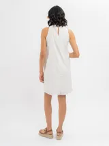 Vestido corto blanco de broderie, sin mangas y con escote halter de corte evasé.