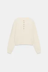 Jersey de punto waffle de algodón color beige, con cuello redondo, cierre frontal parcial con botones en contraste y manga larga con puños elásticos.