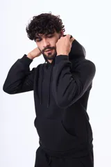 Buzo con capucha y bolsillo frontal tipo canguro, confeccionado en tela de felpa, con cordones ajustables en el cuello y puños elásticos.