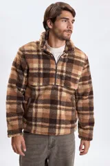 Buzo de sherpa con diseño a cuadros en tonos marrones y beige, cuello alto con medio cierre frontal y bolsillos laterales.