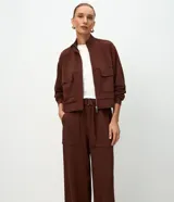 Pantalón wide leg de cintura alta en color marrón, confeccionado en modal con viscosa y elastano. Cuenta con cintura posterior elástica, cinta con hebilla para ajustar, bolsillos delanteros amplios tipo cargo y piernas rectas.