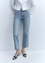 Jeans de denim celestes, de tiro medio y corte recto, con diseño crop y bajo deshilachado. Cuenta con cinco bolsillos, trabillas para cinto y cierre frontal con cremallera y botón metálico.