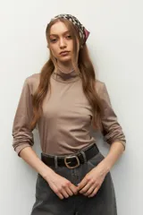 Top tipo polera color marrón claro, de manga larga y corte ajustado al cuerpo.
