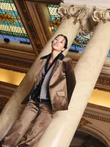 Blazer negro de simil terciopelo con cuello y puños en color marrón. Tiene bolsillos delanteros y forro estampado.