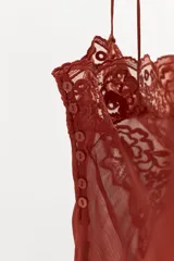 Musculosa de georgette en color bordó, con escote recto, tirantes finos y detalle de aplicación de encaje floral en la parte superior.