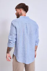 Camisa de corte regular con diseño de rayas verticales finas en tonos claros, cuello clásico y mangas largas con puños abotonados.