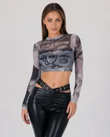 Top de manga larga translúcido de malla en tonos grises y negros, con diseño estampado de rostros de estilo abstracto y corte corto (crop top).