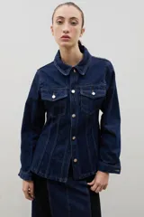 Chaqueta de denim de algodón con corte entallado en la cintura, cuello clásico, cierre frontal con botones metálicos y dos bolsillos con solapa en el pecho.