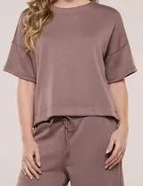 Conjunto de buzo de manga corta con hombros caídos y escote redondo, acompañado de un pantalón tipo wide leg de tiro alto con cintura elástica y cordón de ajuste, en color verde.