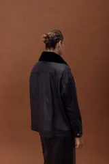 Chaqueta de cuero ovino con efecto gastado, estilo jeanero, con cierre frontal de botones metálicos y bolsillos frontales. Posee mangas largas con puños y un cuello desmontable de corderito negro.