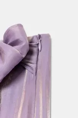Pantalón de tiro alto con diseño cruzado tipo pareo, pernera ancha y detalle de lazada lateral. Presenta un acabado con efecto brillante.