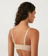 Soutien femenino modelo top, color piel, con copa hueca y tirantes removibles.