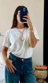 Collar dorado con cadena de eslabones grandes y dije circular con diseño de sol.