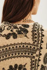 Sweater de punto con diseño estampado estilo paisley en tonos beige y negro, de cuello redondo y manga larga.