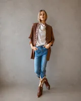 Tapado largo estilo blazer en color chocolate, con cuello mao y cierre frontal de botones metálicos decorativos. Presenta un corte estructurado y mangas tres cuartos.