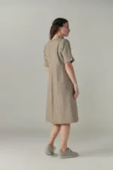 Vestido a la rodilla color beige, con escote en V, mangas 3/4 y bolsillos laterales.