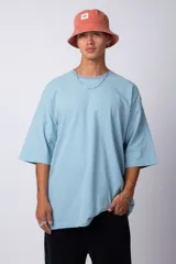 Remera de corte oversize, color blanco, con cuello redondo y mangas cortas amplias, confeccionada en algodón.