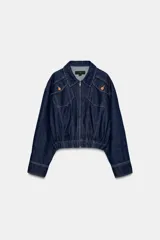 Chaqueta estilo bomber confeccionada en tejido denim azul oscuro. Presenta cuello solapa, cierre frontal con cremallera, mangas largas y bajo elástico. Incluye bolsillos delanteros de plastrón con solapa y botones.