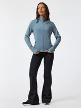Campera deportiva de segunda capa confeccionada en tejido suave melange color celeste. Cuenta con cuello alto, cierre frontal completo, bolsillos laterales con cierre y orificios para los pulgares en los puños.
