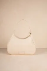 Mini bag color crema en símil cuero texturizado con asa fija.