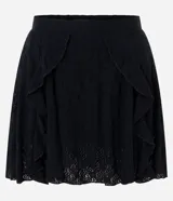 Pollera corta de encaje floral color negro, de talle alto y corte evasé, con volados y paneles superpuestos en el frente.