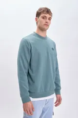 Sudadera verde de cuello redondo y manga larga, con puños y cintura acanalados. Estampado de un escorpión en el pecho.
