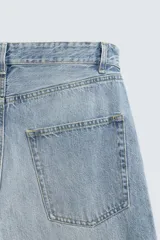 Jeans de denim de algodón, color azul oscuro con efecto lavado. Presentan un corte muy holgado (baggy fit) en toda la pierna y tiro medio. Tienen cinco bolsillos y cierre frontal con cremallera y botón.