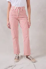 Pantalón de jean de corte recto, tiro medio, con estampado a rayas verticales rojas y crudas y cierre frontal con botones.