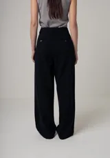 Pantalón de vestir color beige, de corte palazzo, con bolsillos laterales y traseros.