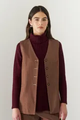 Chaleco azul con cuello en V y cierre frontal con botones marrones.