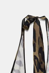 Vestido largo con cuello halter que se ata en la nuca, escote pico pronunciado y estampado de leopardo en tonos marrón y negro.