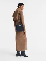 Cartera de mano Le Roseau S de Longchamp, color negro, confeccionada en cuero con textura granulada. Cuenta con asas superiores rígidas, una correa ajustable y extraíble para llevar cruzada o al hombro, y cierre de solapa con el característico pasador metálico de bambú de la marca.
