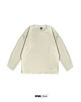 Buzo color crema de lana premium con textura acanalada y costuras expuestas.