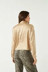 Camisa negra de satén con corte relajado y largo a la cadera.